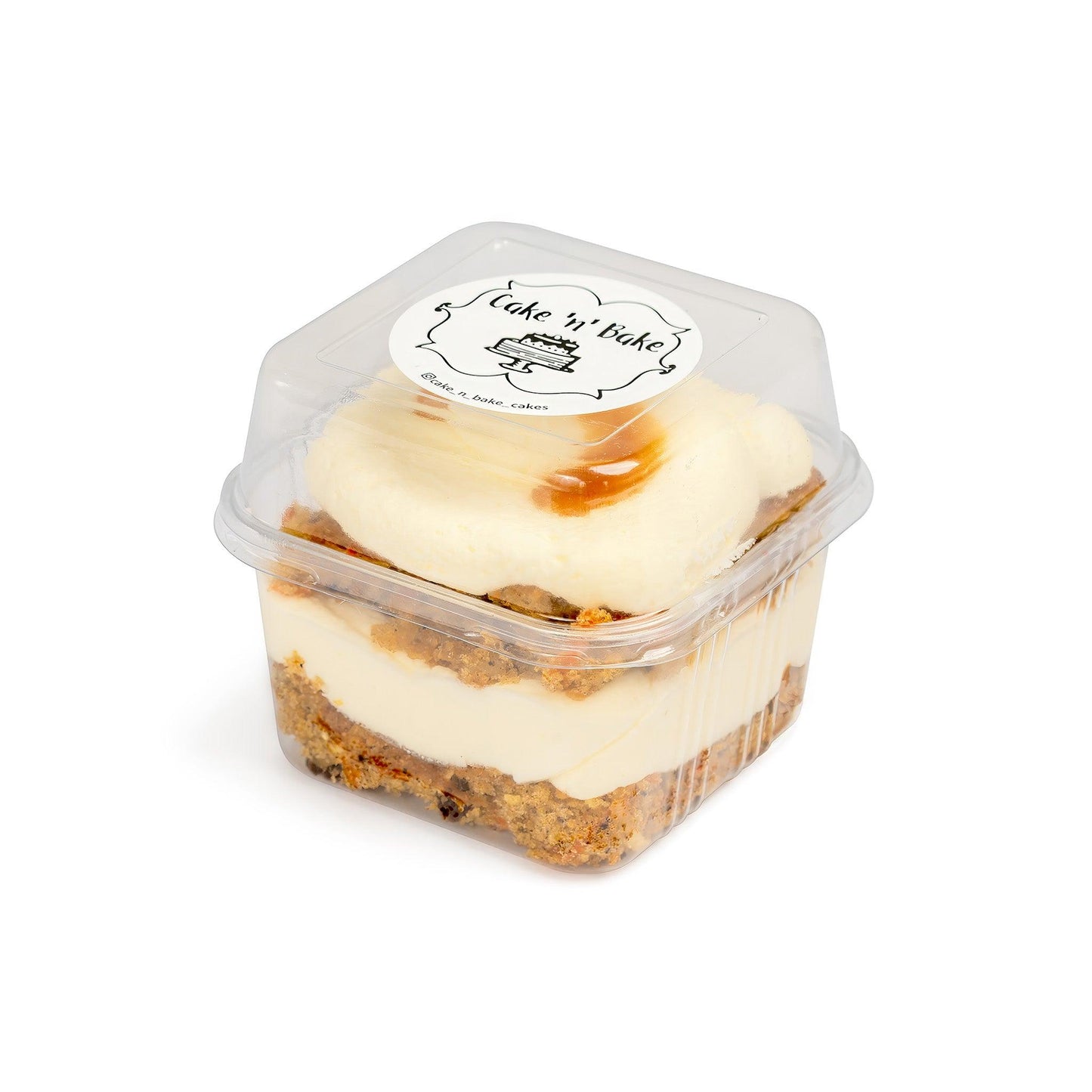 Carrot Cake Cup with a clear lid featuring the Cake Nā Bake logo, showcasing layers of carrot cake, cream cheese frosting, and caramel drizzle, perfect for individual servings.
